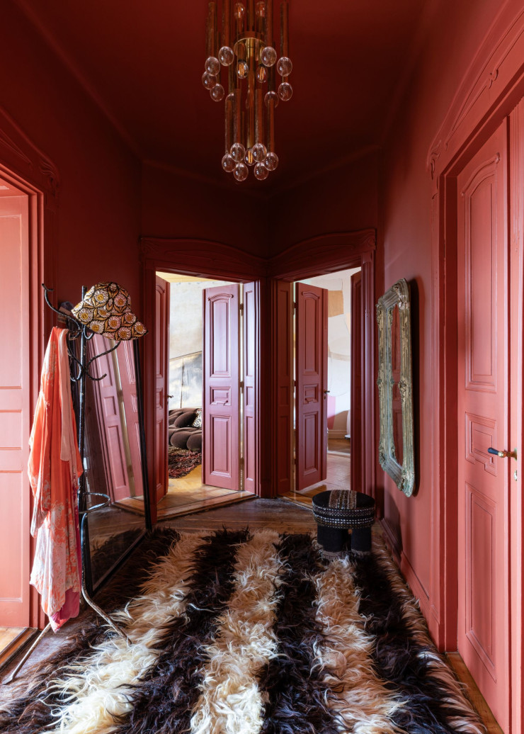 Dans le couloir menant aux chambres, tapis en laine dessiné par la propriétaire et confectionné à la main. Le tabouret noir a été fabriqué par Marie à partir de vieux rideaux des années 70. Le miroir (à droite) est une pièce ancienne datant de 1880 et dénichée à Prague.