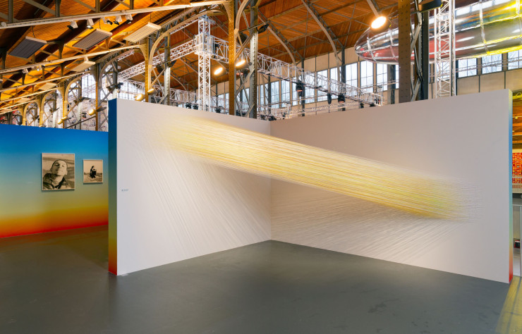 L’installation Reaching Sun, d’Anne Lindberg (2023), est composée de plusieurs milliers de fils de coton vibrant au gré de la lumière. Une oeuvre qui donne une matérialité au concept