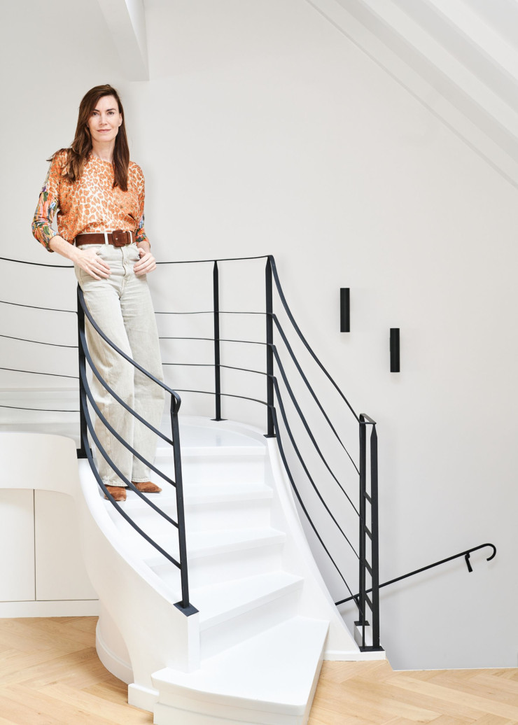 L’architecte d’intérieur Nancy Geernaert sur l’escalier dont la rampe a été conçue par son studio, Just’in Design, et réalisée par la société Ruvaly. Il est un élément essentiel du rajeunissement accordé à ce duplex de rêve.