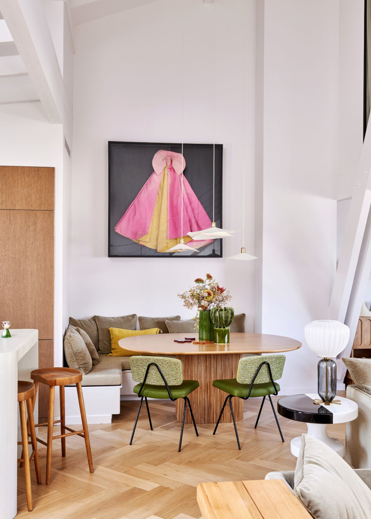 Le coin salle à manger a été intégré dans une alcôve attenante à la cuisine. La table Tamula (La Redoute) s’entoure de chaises chinées et d’une banquette conçue sur mesure. Sur un tabouret Bishop en céramique, lampe de table Don Giovanni, les deux signés India Mahdavi. Tabourets de bar et suspensions Zara Home. Photographie de Karen Knorr.