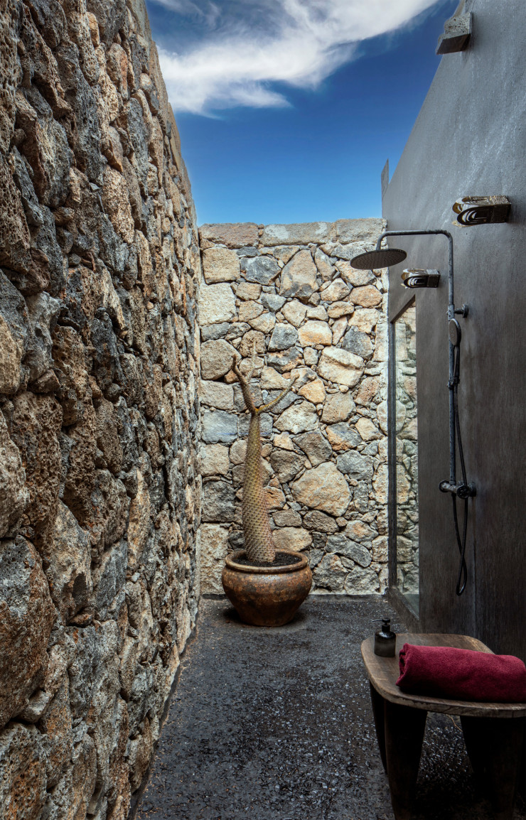 Douche extérieure entourée d’un mur en pierre naturelle. © Helenio Barbetta