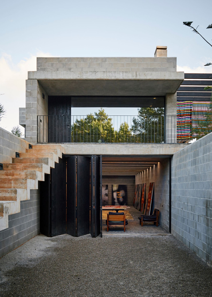 Dans le sous-sol de la maison brutaliste, qui compte trois niveaux, Stefan Brüggemann a installé son atelier. Ce dernier est doté d’une porte concertina en yakisugi (bois brûlé).