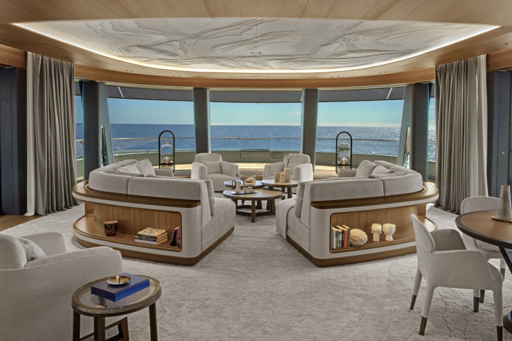 L’espace libéré à l’avant du pont supérieur est occupé par le grand salon de 85 m2 , ce qui permet d’offrir la meilleure vue sur la mer. Le mobilier du yatch Kensho a été conçu sur mesure. Les luminaires, créés par Jouin Manku avec Preciosa, sont une interprétation de la lampe-tempête. Au plafond, le décor est une évocation des cartes de navigation.