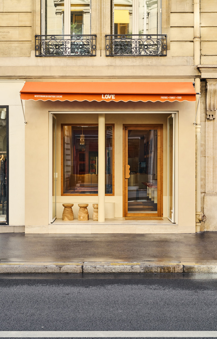 La façade du Love avec son patio d’entrée et ses tabourets en bois, un clin d’œil à l’art de vivre en  extérieur du Sud.