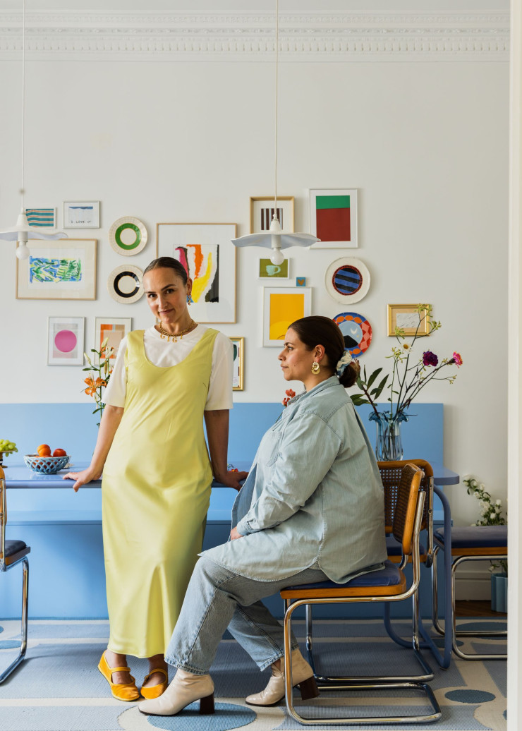 Alice Gras (debout) et Anaïs Seguin dans leur salle à manger. Anaïs est assise sur une chaise B32, de Marcel Breuer, chinée et retapissée de velours. Tapis Normandie Laine (Casa Lopez).