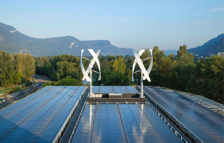 À Grenoble, le bâtiment Schneider Electric produit sa propre énergie, grâce à 4000 mètres carrés de panneaux photovoltaïques installés sur son toit et deux éoliennes verticales.