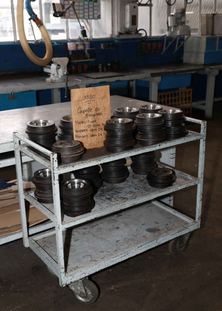 Sur un chariot logistique, une série de moules, soupapes et poinçons sont préparés pour la prochaine production des coupelles en verre.