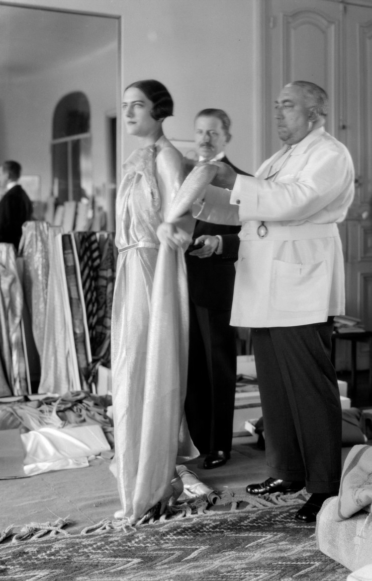Thérèse Bonney (1894-1978). Paul Poiret et le mannequin Renée dans les salons de sa maison de couture, 1 rond-point des Champs-Elysées. 1927. Tirage gélatino-bromure d’argent par l’ARCP, [198.], d’après le négatif. Bibliothèque historique de la Ville de Paris