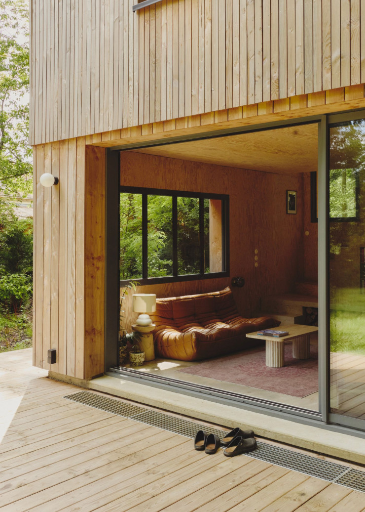 Au rez-dechaussée, les parties communes s’ouvrent sur une belle terrasse en connexion directe avec la nature. Dans le salon, une sélection de mobilier et d’objets contemporains ou chinés.