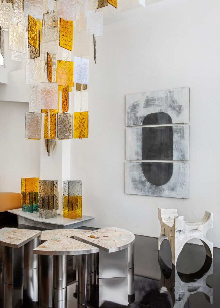 Le lustre modulaire Paysage pour Spotti Edizioni Milano et les lampes de tables Lina pour la galerie Blend Roma, réalisés par le jeune verrier de Murano 6.AM. Tables basses Sole en métal et plateau de mosaïque de marbre Arabescato réalisé par l’artiste Paolo Racagni de Ravenne. Totem, un fauteuil sculptural, indoor et outdoor, constitué de différentes couches récupérées de marbre Calacatta, réalisé par Fratelli Marmo.