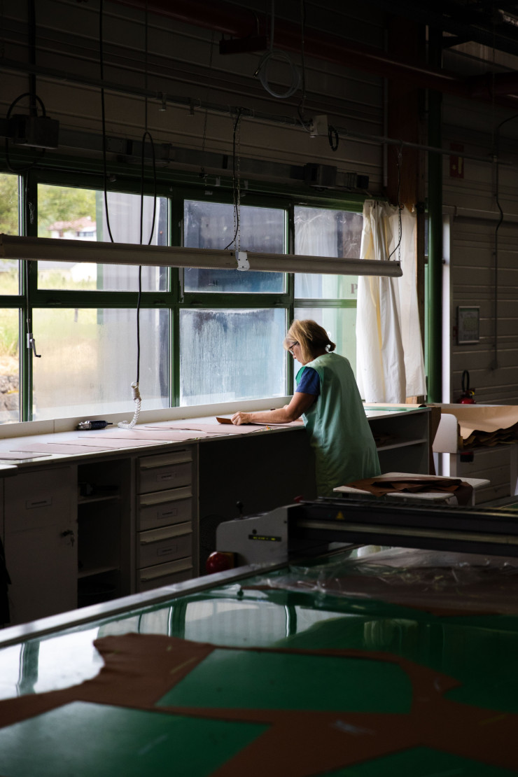 Dans l’atelier cuir, une contrôleuse vérifie chaque empiècement de peau prédécoupé afin de s’assurer de l’absence de défaut.