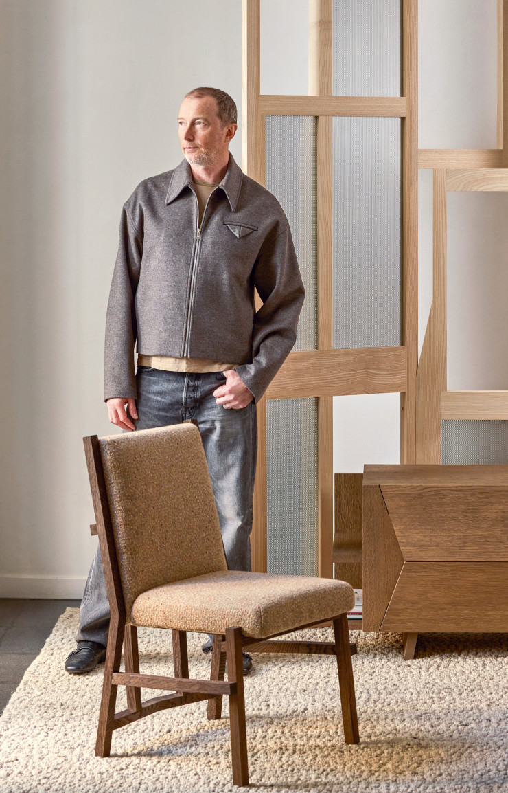 Christophe Delcourt, entouré de la chaise Yug en bois, du paravent Yoa en frêne et de la commode basse Ost en chêne brossé (Delcourt Collection).