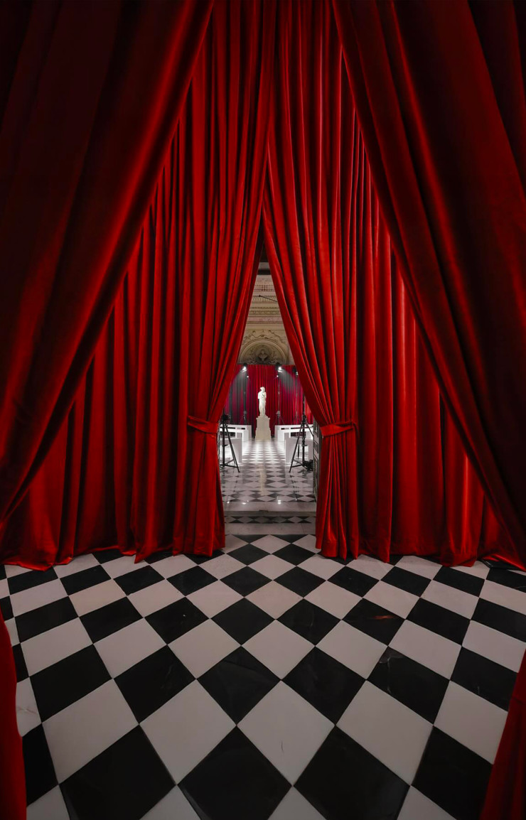 Le décor du défilé automne-hiver 2025/2026 de Marine Serre au rideaux de velours cherry red.