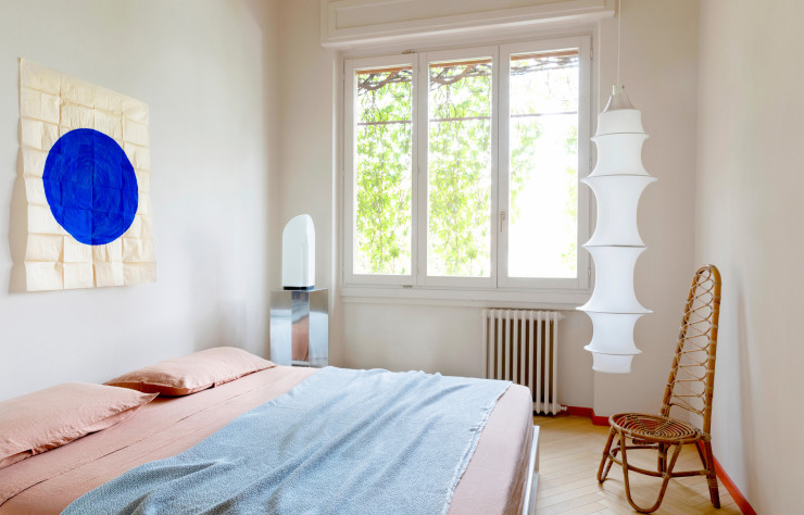 Dans la chambre, lit Asha Basic, de Studio Progetti (Xam). Linge de lit Rem et plaid Nid (Society Limonta). Stèle en métal NM3. Lampe de bureau Tiki, de Kazuhide Takahama (Leucos). Chaise vintage Bonacina. Suspension Falkland, de Bruno Munari (Danese Milano). Au mur, acrylique sur papiercalque TIMELESS 2023, de Nicolas Denino.