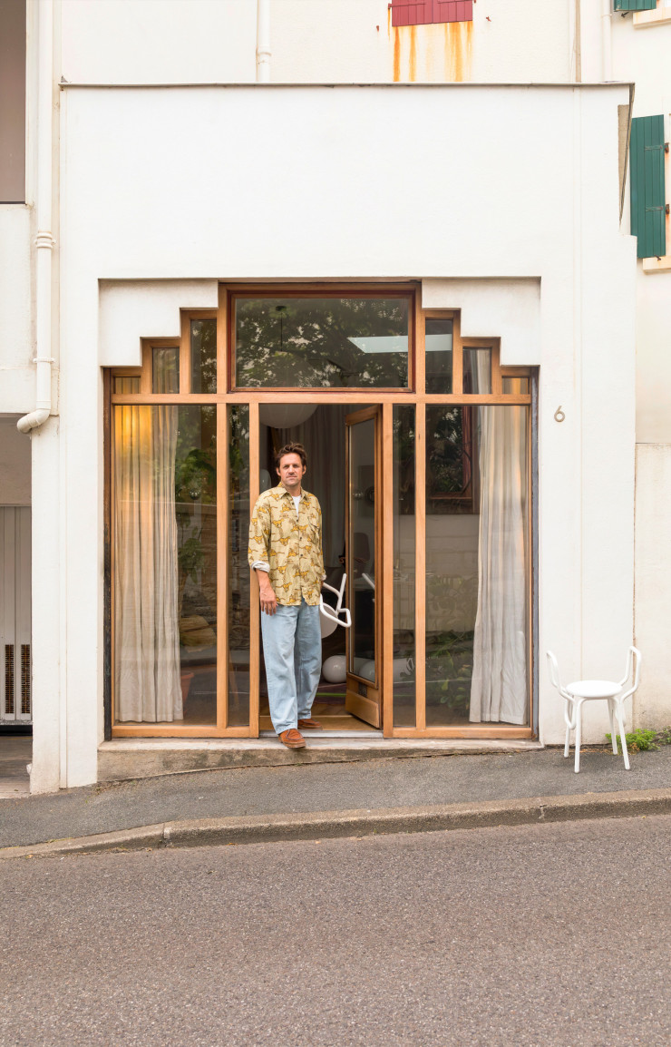 Jean-Baptiste Fastrez à l’entrée de son studio biarrot avec, en main et sur le trottoir, ses tabourets empilables FZ1 en bois et en aluminium (EO).